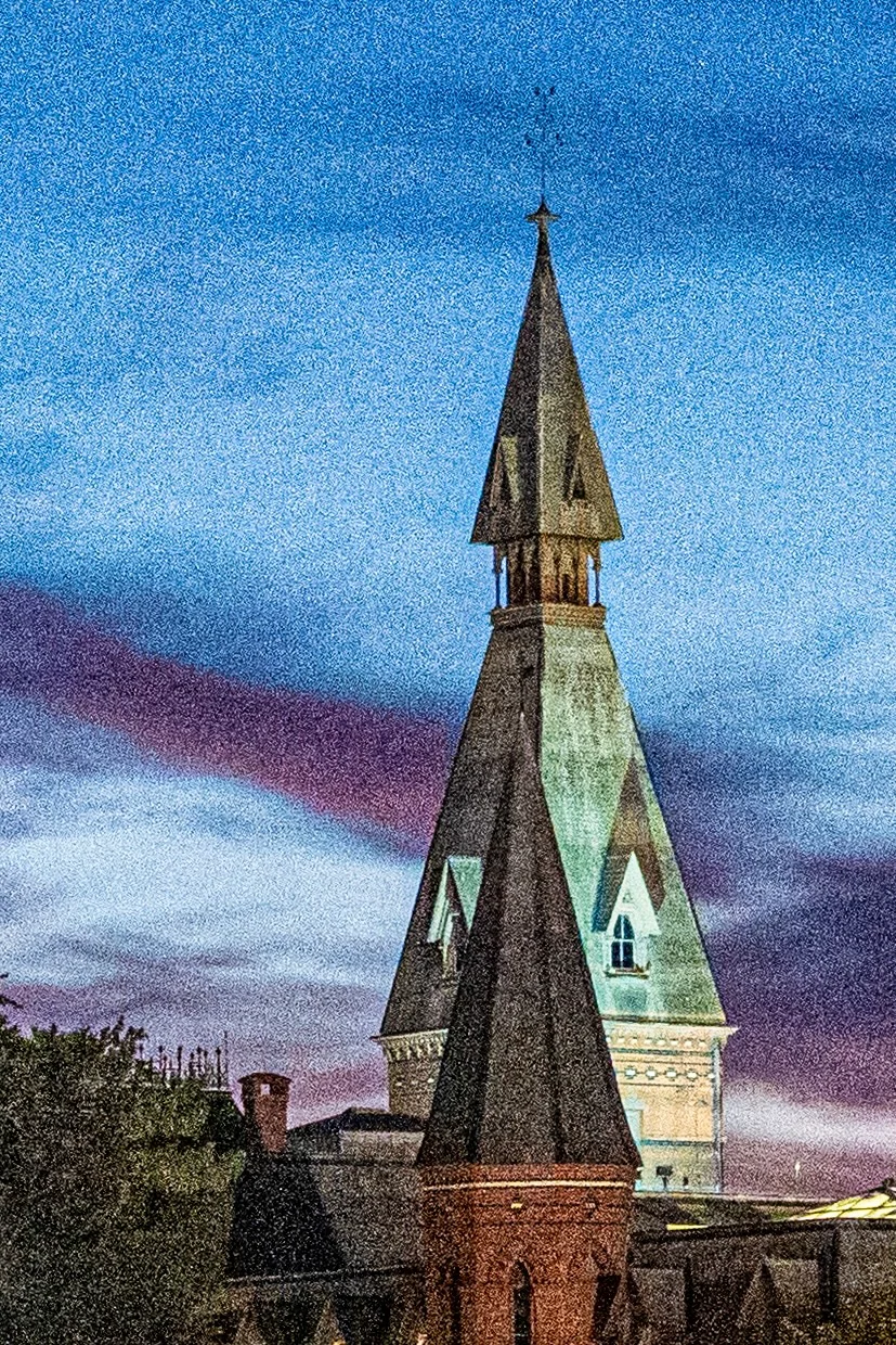 A tall stone tower beneath a purple-blue evening sky