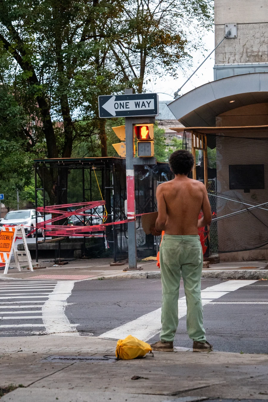 A person waiting at a neighborhood street corner