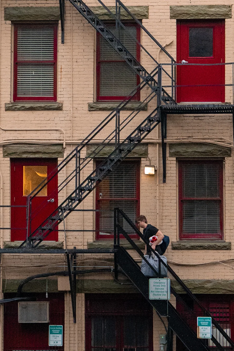 Red doors and a fire escape on a brick building