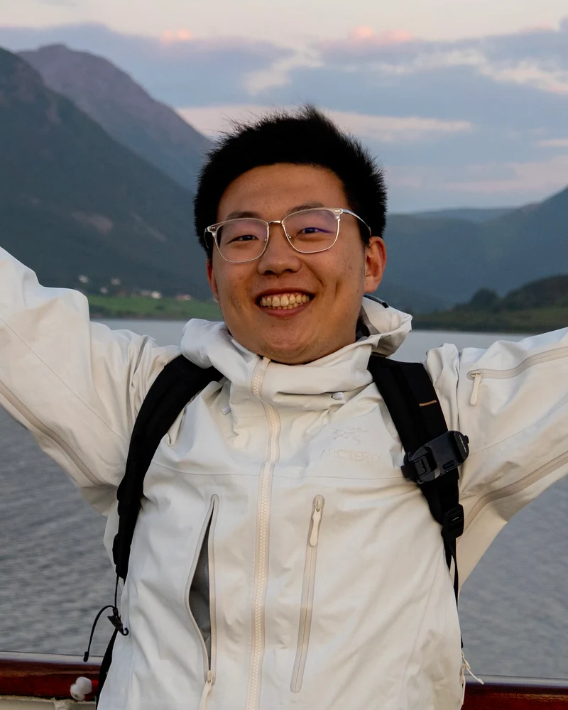 Qianxu on a boat with mountains in the background